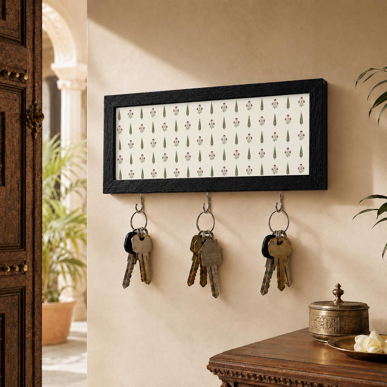 Decorative key holder with keys on a wall next to a wooden door.