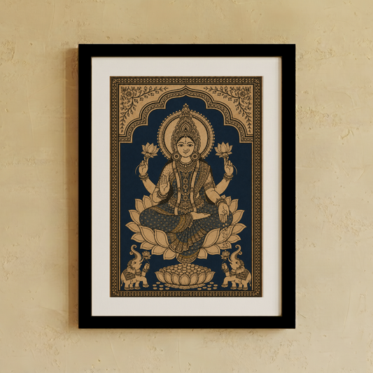 A framed art print of a Hindu goddess seated on a lotus, shown hanging on a textured beige wall. The print features a dark navy blue background with intricate gold illustrations, surrounded by a white mat and a simple black frame.