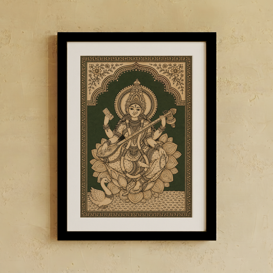 Framed wall art featuring a detailed tan and dark green illustration of the Hindu goddess Saraswathi seated on lotus flowers, displayed on a textured beige wall.