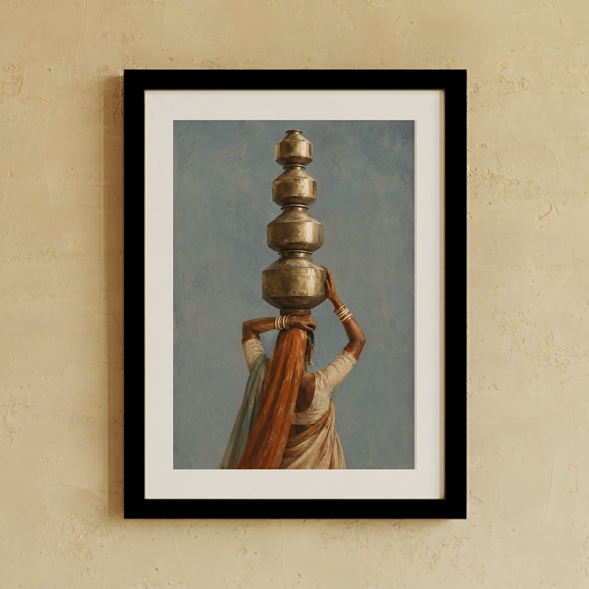 Framed art print featuring a woman carrying stacked metallic pots on her head against a muted blue-gray sky, displayed on a textured beige wall.